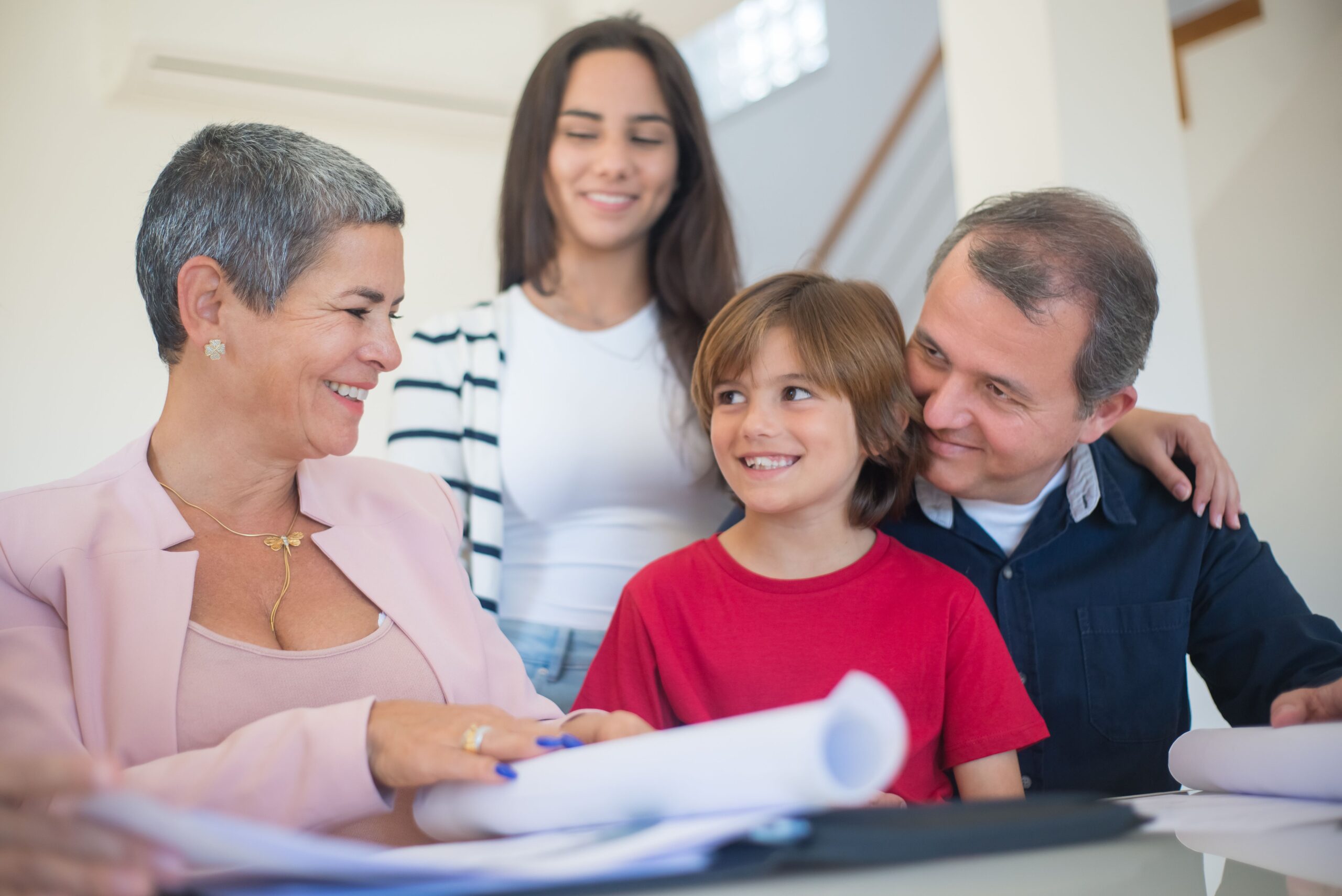 pexels-kampus-8729963 Smiling family indoors signing real estate documents. Friendly interaction and teamwork.